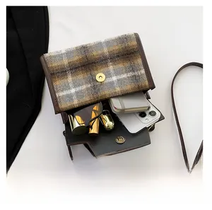 Detail view showing interior capacity for phone and sunglasses in plaid wool shoulder bag