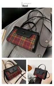 Detail showing the red plaid texture and black leather stitching of the square handbag