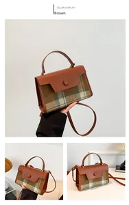 Detail view of the brown leather and plaid fabric texture with a round buckle