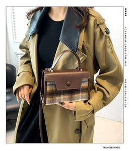 Detail of retro plaid wool and brown leather crossbody bag with rounded button clasp