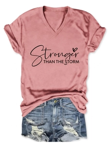 Flat lay di una t-shirt scollo a V rosa antico con testo e pantaloncini in denim