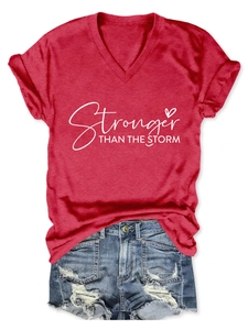 Dettaglio ravvicinato della t-shirt rossa con scollo a V e stampa abbinata a shorts in denim