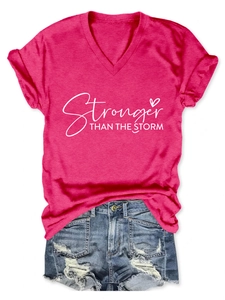 Dettaglio maglietta rosa scollo a V con stampa bianca Stronger e pantaloncini in denim blu