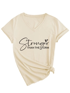 Dettaglio della stampa e del nodo sull'orlo della t-shirt beige da donna con scollo a V