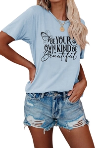 Detail of the butterfly print and 'BE YOUR OWN KIND OF Beautiful' text on the blue T-shirt