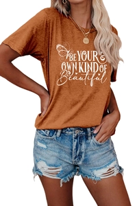 Detail of caramel orange t-shirt with white butterfly graphic and inspirational text