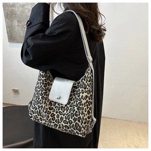 Detail view of leopard print canvas shoulder bag with grey leather flap and silver buckle
