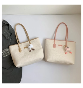 Détail d'un grand cabas avec motifs de dessins animés gaufrés et pendentifs en peluche