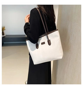 Close-up of white tote bag with brown handles and JINGPIN logo detail in studio light