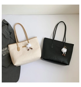 Détail de sacs fourre-tout avec motifs de dessins animés gaufrés et breloque peluche