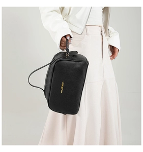 Macro view of black lychee grain PU leather makeup bag with gold logo and sturdy handle