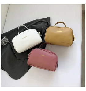 Detailed view of three textured PU leather makeup bags in white, yellow, and dusty rose