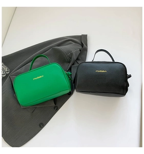 Close-up of double zipper travel makeup bags in green and black with lychee grain texture