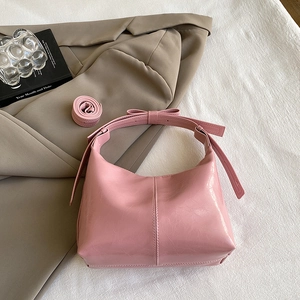 Sac seau hobo rose brillant avec bandoulière à nœud et sangle sur fond de tissu