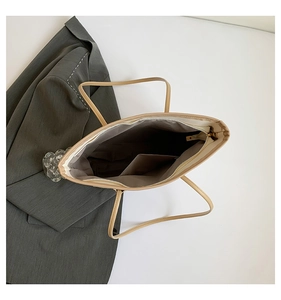 Internal view of beige tote bag showing dark lining, inner pocket and zipper closure