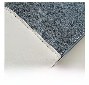 Detail shot of the contrast stitching and grey tweed fabric texture on a crossbody bag