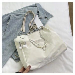 Détail du sac cabas en velours blanc avec chaîne argentée, perles et gri-gri nuage