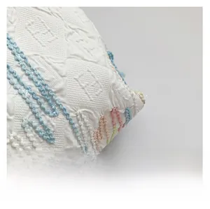 Close-up of white embossed fabric with colorful rainbow stripes and textured pattern
