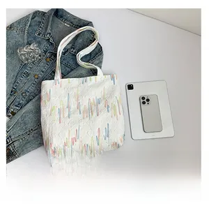 Detailed close-up of quilted tote bag featuring colorful wavy embroidery and daily items