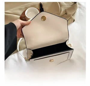 Vue intérieure d'un petit sac bandoulière blanc montrant le compartiment et le fermoir aimanté