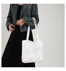 Fashionable white canvas tote bag with colorful embroidery shown on model for daily commute