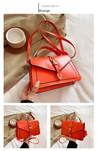 Détail du sac à bandoulière orange montrant la texture du cuir PU et la boucle en métal