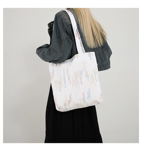 Detail of white tote bag featuring colorful vertical stripes and unique pleated texture