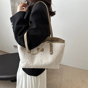 Fuzzy white sherpa tote bag with khaki straps worn by a model in a minimalist setting
