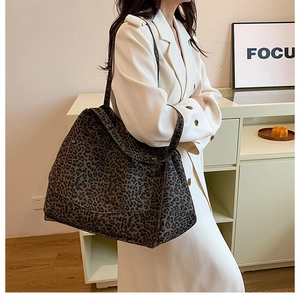 Detailed view of leopard print tote bag styled with a minimalist beige coat
