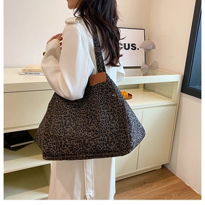 Detail of leopard print tote bag with large side pocket shown on shoulder