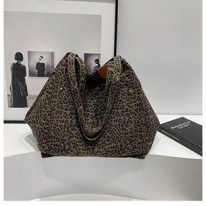 Detail of leopard print tote bag with front pocket, metal rivets and leather label