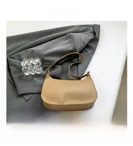 Detail of khaki crescent underarm bag with lychee grain texture on grey suit