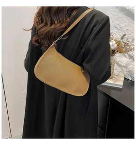 Close-up of light brown leather texture and stitching on a baguette shoulder bag