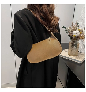 Detail showing the lychee grain texture and crescent silhouette of this brown shoulder bag