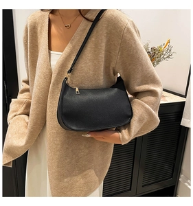 Classic black leather baguette bag styled as a shoulder bag on a female model
