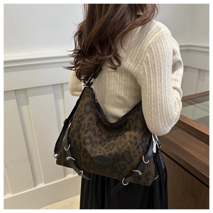 Detail der Leopard-Print-Tasche mit schwarzen Riemen und hochwertigen Metallringen