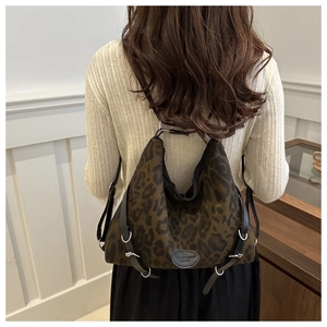 Detailansicht der Vintage-Tasche mit Leopardenmuster, schwarzem Gurt und Metallschnalle