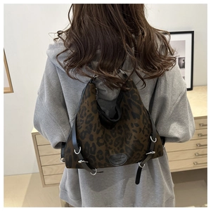Nahaufnahme der Schultertasche mit Leopardenmuster, schwarzen Lederbesätzen und Schnallen
