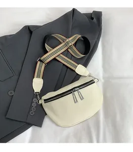 Détail du sac selle blanc cassé avec bandoulière rayée vintage et doubles zips argentés