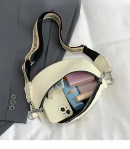 Vue détaillée du sac besace crème avec intérieur spacieux et bandoulière rayée