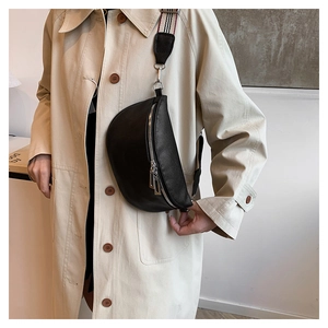 Détail du sac selle en cuir grainé noir avec large bandoulière tissée à rayures