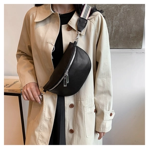 Détail du sac selle en cuir grainé noir avec une large bandoulière tissée à rayures