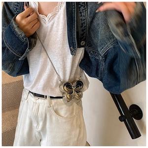 Détail du mini sac papillon argenté avec une fine bandoulière en chaîne métallique