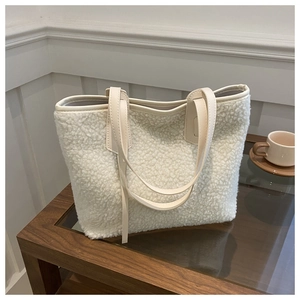 Minimalist creamy white fleece tote bag with leather handles in a cozy home setting