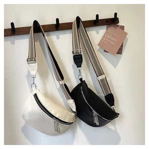 Détail de sacs selle vintage en cuir texturé avec de larges bandoulières rayées