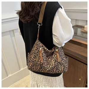 Detail view of large leopard print tote bag with wide strap and side zip pockets