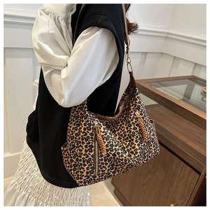 Detail of leopard print tote bag featuring a front zipper pocket and side pockets