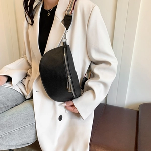 Sac ceinture noir en cuir avec bandoulière rayée colorée porté par un mannequin