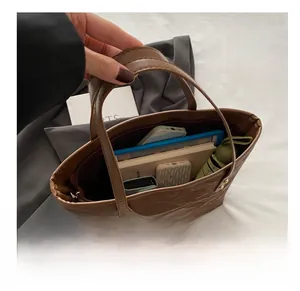 Detailed internal view of brown leather tote bag showing large storage capacity for items