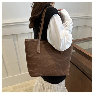 Detail of brown pleated texture tote bag featuring minimalist large capacity design